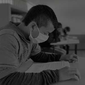 studiante con tapabocas realizando examen.